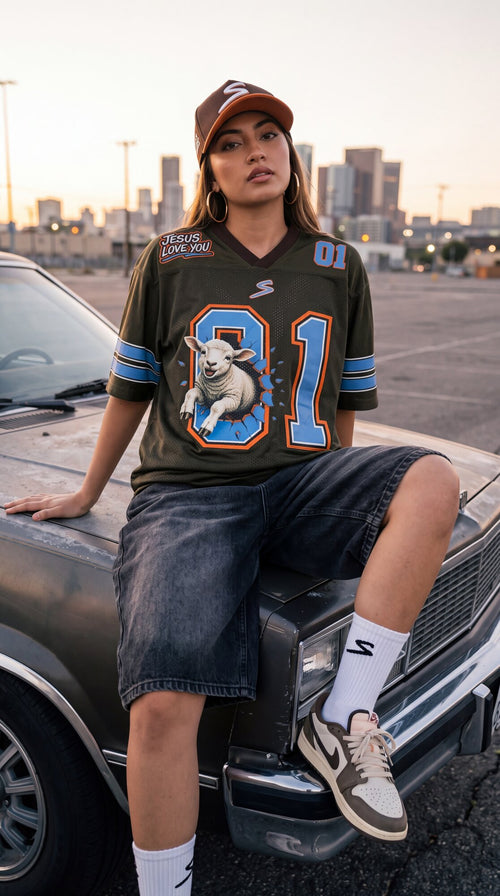 Modelo con The Lost Sheep Jersey 01 de SENT sentada sobre un carro clásico con el skyline de fondo